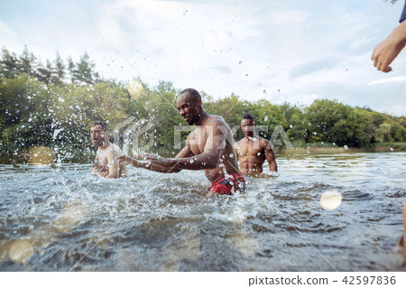 Enjoying river party with friends. Group of beautiful happy young people at the river together Enjoying river party with friends. Group of beautiful happy young people at the river together 42597836