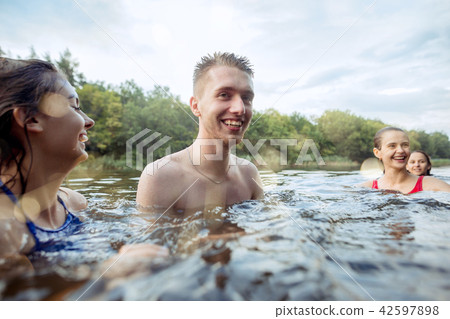 Enjoying river party with friends. Group of beautiful happy young people at the river together 42597898