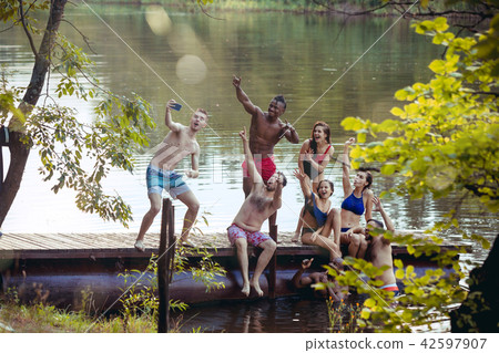 Enjoying river party with friends. Group of beautiful happy young people at the river together 42597907
