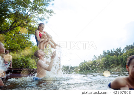 Enjoying river party with friends. Group of beautiful happy young people at the river together 42597908