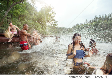 Enjoying river party with friends. Group of beautiful happy young people at the river together 42597918