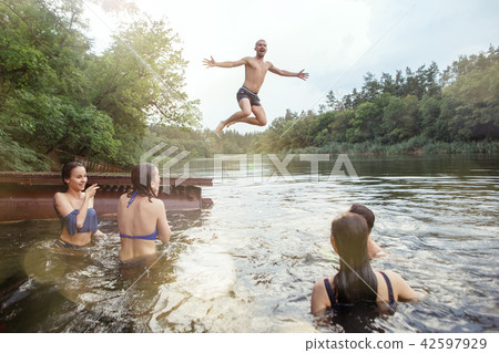 Enjoying river party with friends. Group of beautiful happy young people at the river together 42597929