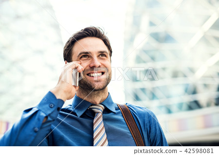 A young businessman with smartphone, making a phone call. Copy space. 42598081