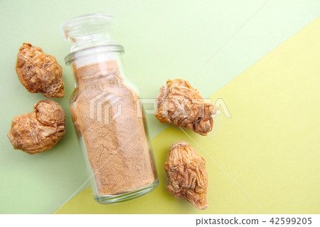 Glass bottle containing dry maca and maca powder 42599205