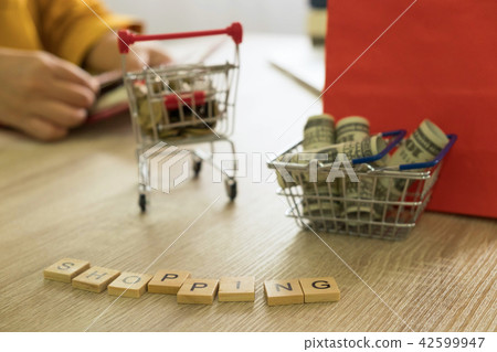 Money in a basket and coin in a trolley on table  42599947