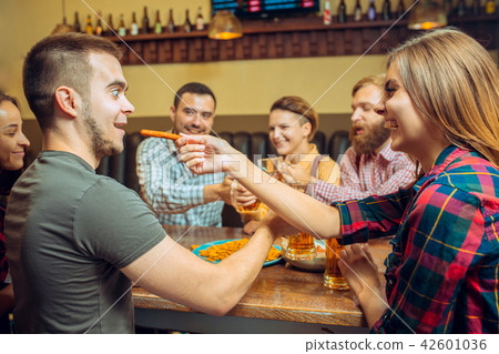people, leisure, friendship and communication concept - happy friends drinking beer, talking and people, leisure, friendship and communication concept - happy friends drinking beer, talking and 42601036