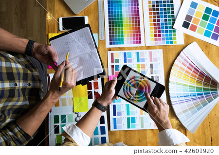 Graphic designers use the tablet to choose colors. 42601920