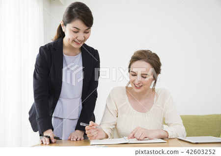 A Japanese woman talking to a foreign woman 42603252