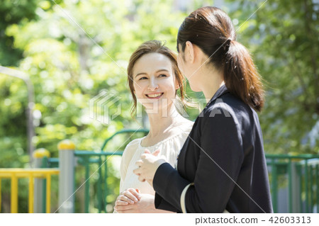 A Japanese woman talking to a foreign woman 42603313
