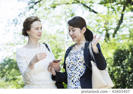 A Japanese woman talking to a foreign woman 42603407