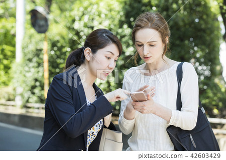 A Japanese woman talking to a foreign woman A Japanese woman talking to a foreign woman 42603429