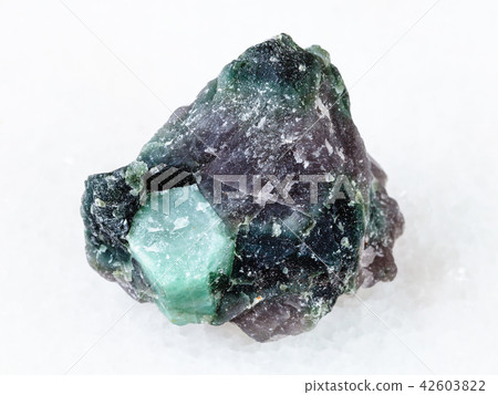 rough crystal of Beryl gemstone in rock on white 42603822