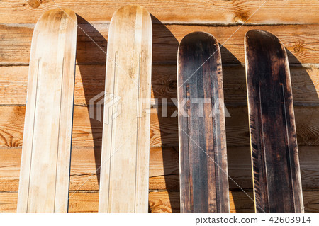 wide forest skis near wooden wall of country house 42603914