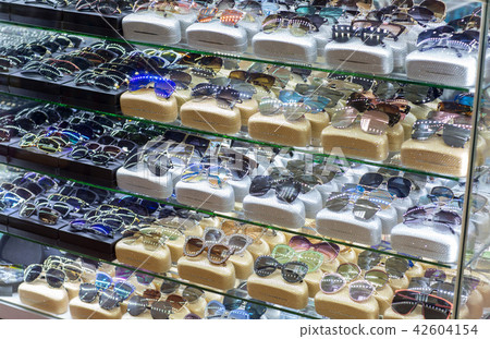 Various Sunglasses on display shelf in shop 42604154