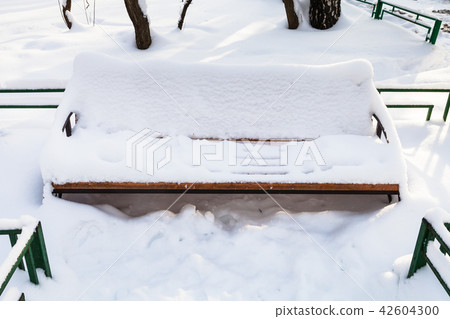 snow-covered bench at urban square in winter snow-covered bench at urban square in winter 42604300