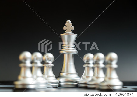 Silver king chess piece stand with pawn 42604874