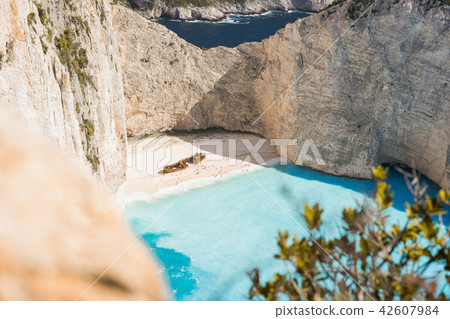 Famous shipwreck on Navagio beach with turquoise blue sea water surrounded by huge white cliffs Famous shipwreck on Navagio beach with turquoise blue sea water surrounded by huge white cliffs 42607984