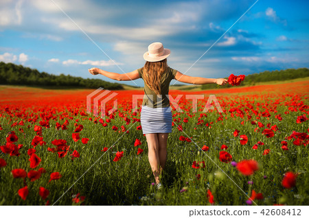 Portrait of beautiful young woman in the field of red poppies Portrait of beautiful young woman in the field of red poppies 42608412