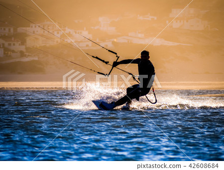 professional kiter makes the difficult trick on a beautiful back professional kiter makes the difficult trick on a beautiful back 42608684