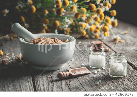 Mortar of healing herbs and homeopathic globules. 42609172