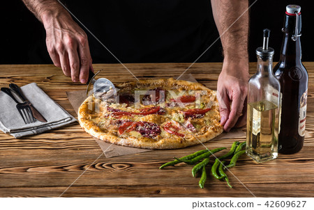 Pizza with a bottle of beer on a wooden table 42609627