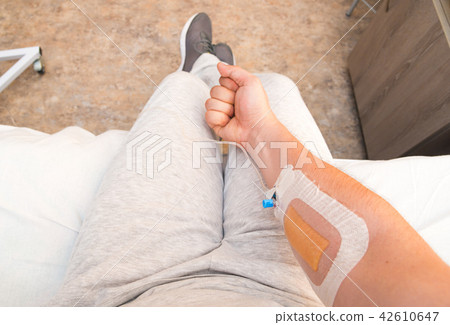 Patient's hand with fist with Infusion catheter 42610647