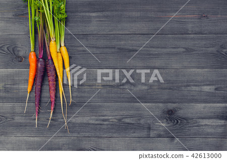 Bright colorful carrots on the wooden table Bright colorful carrots on the wooden table 42613000