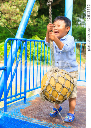 A boy playing with park play equipment A boy playing with park play equipment 42613552