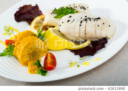 Codfish steamed and served with boiled corn, herbs and lemon 42613998