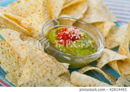 Nachos with guacamole on blue plate 42614465