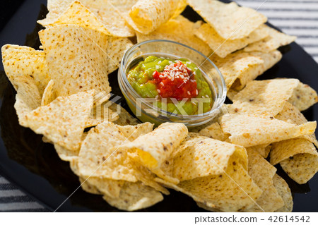 Nachos chips with sauces on black plate Nachos chips with sauces on black plate 42614542
