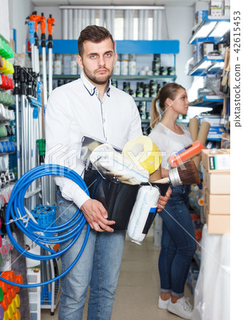 Man choosing instruments in household store Man choosing instruments in household store 42615453