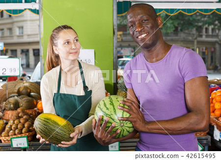Seller female is helping man choose watermelone 42615495