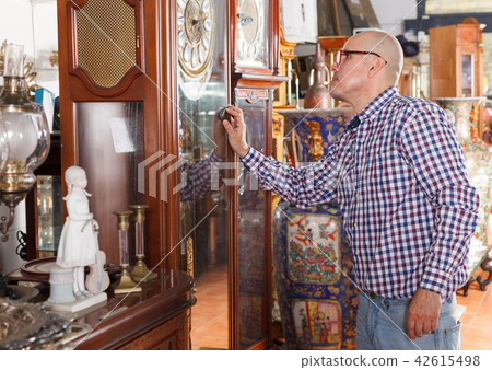 man pensively looking atantique clock 42615498
