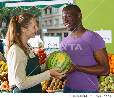 Seller female is helping man choose watermelone 42615564