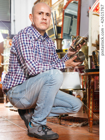 Portrait of successful owner of antiques shop among vintage things 42615767
