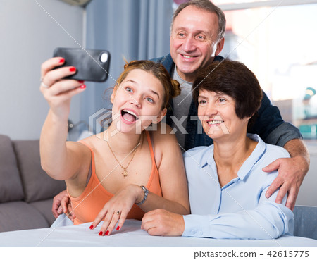 Smiling woman with her parents are taking selfie on the phone Smiling woman with her parents are taking selfie on the phone 42615775