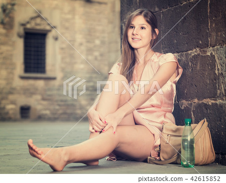 young girl in romantic dress sitting in town 42615852