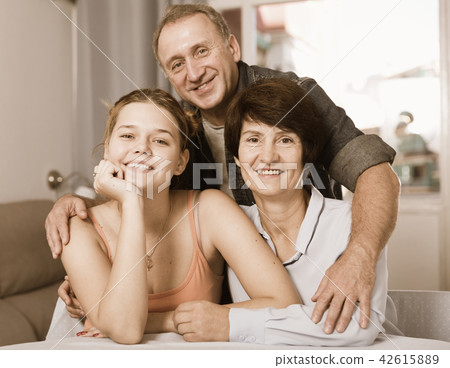 Portrait of marrieds with their adult daughter at the table 42615889