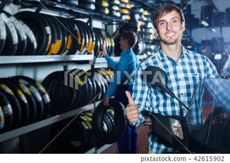 Positive man customer holding his motorcycle 42615902