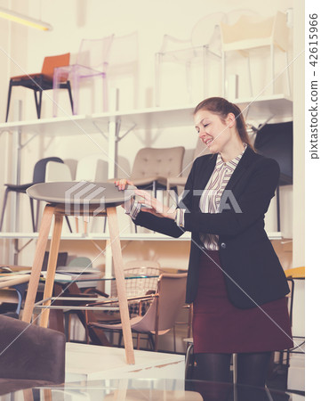 Girl choosing chairs in store Girl choosing chairs in store 42615966