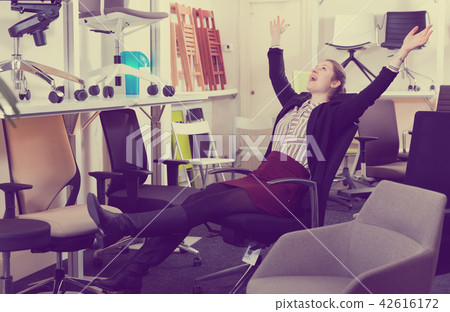 Satisfied woman in office chair in store 42616172