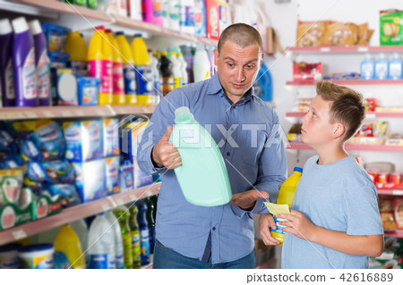 Man and boy buying household chemicals with shopping list 42616889