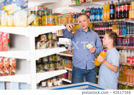 Father doing shopping with boy looking at shopping list 42617168