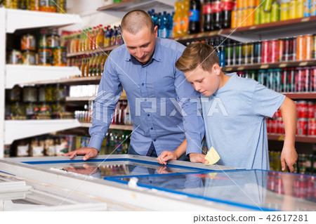 Father doing shopping with boy looking at shopping list 42617281