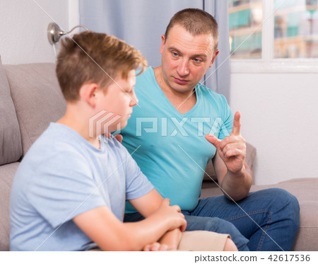 Adult male with his anxious son are resting together and talking about teenage secrets 42617536