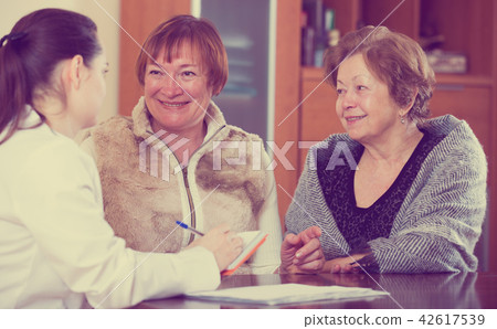 Female therapeutist consulting senior patients in clinic 42617539