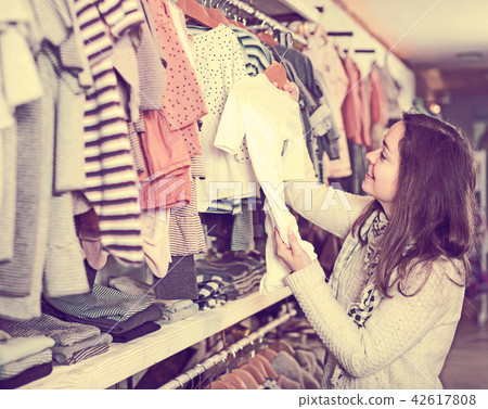 Woman examining romper suits Woman examining romper suits 42617808