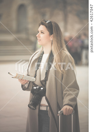 traveling girl searching for the direction using a booklet in the town 42617847