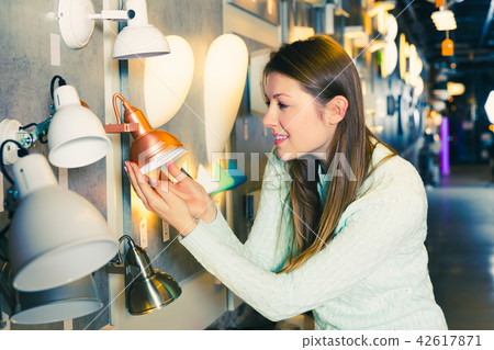girl touching torchere in furniture store girl touching torchere in furniture store 42617871